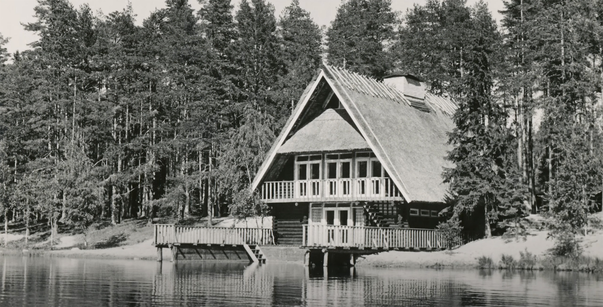 Mustvalge foto majast vee ääres